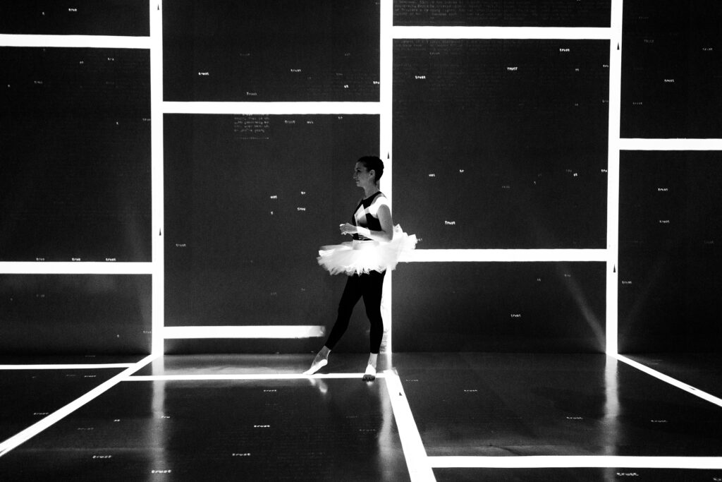 Sara dancing in a room outlined by brilliant geometric light.
