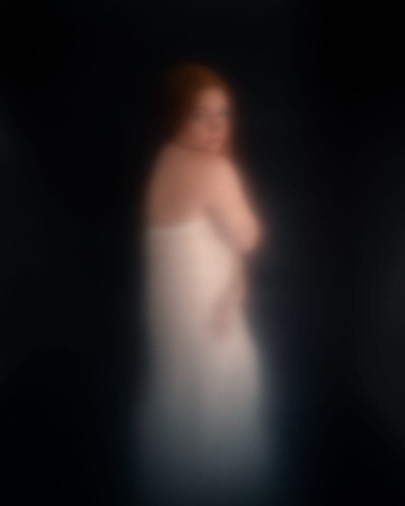 Elizabeth looks over her shoulder, her white dress and red hair softened into a blurred silhouette.
