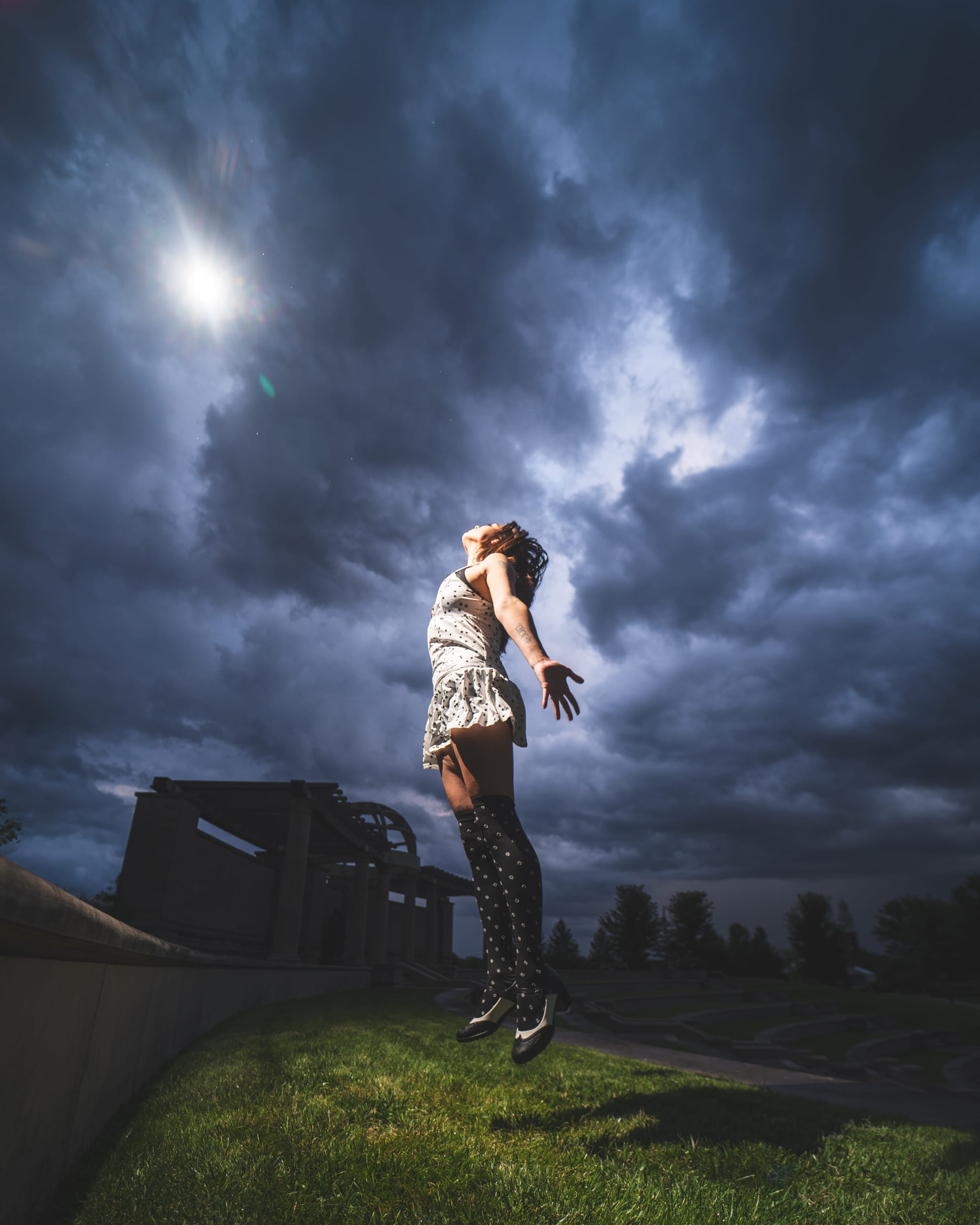 Reese appears to float above the grass beneath a swirling blue storm sky.