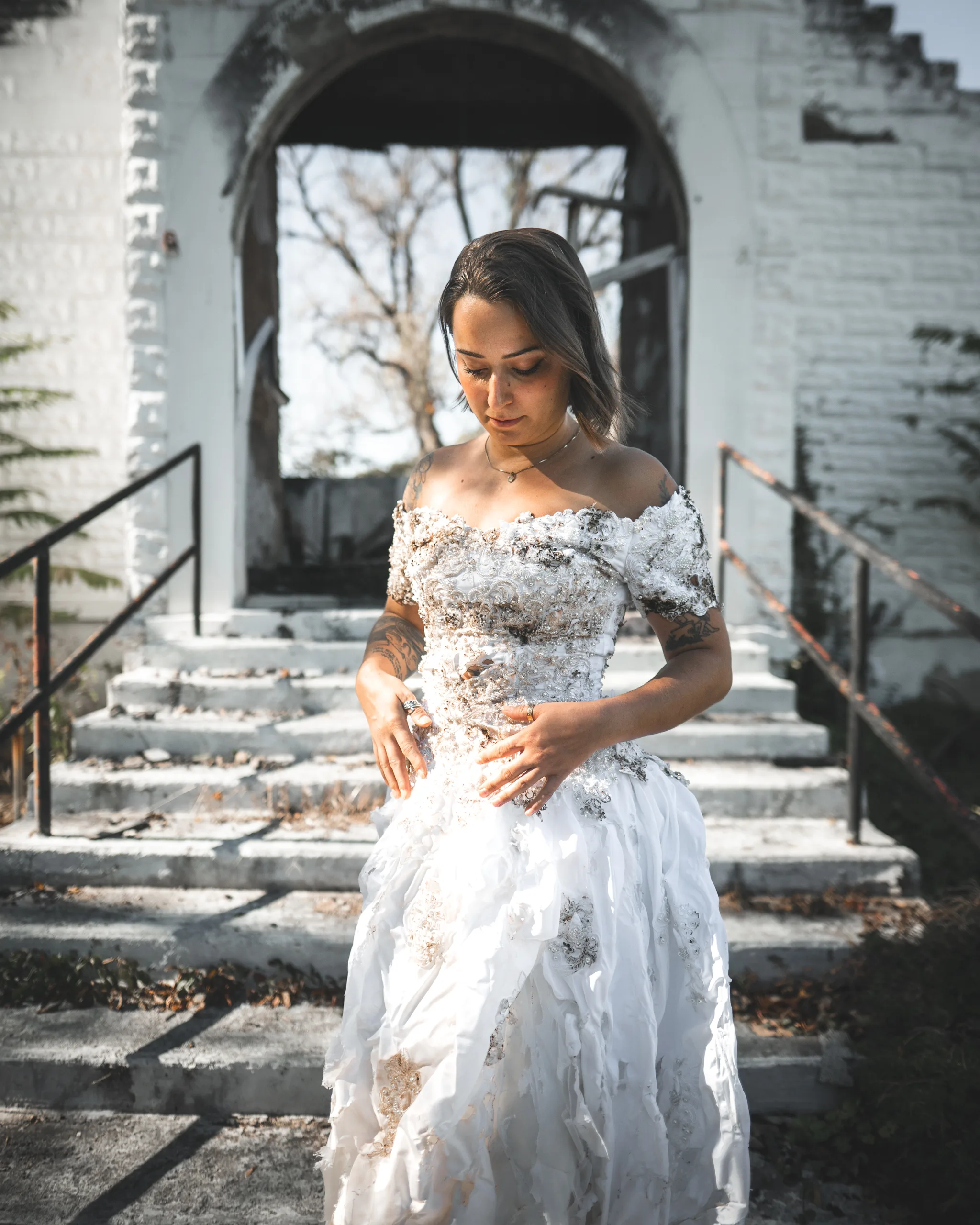Kaitlyn looks down at the distressed wedding dress in front of the church doorway.